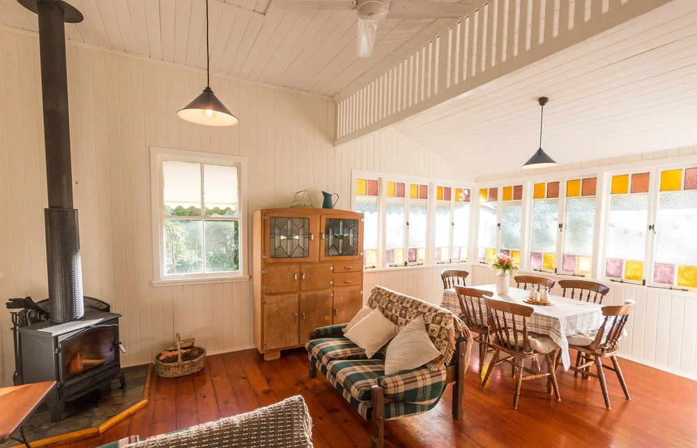 Restored Queenslander living and dining room with coloured glass windows